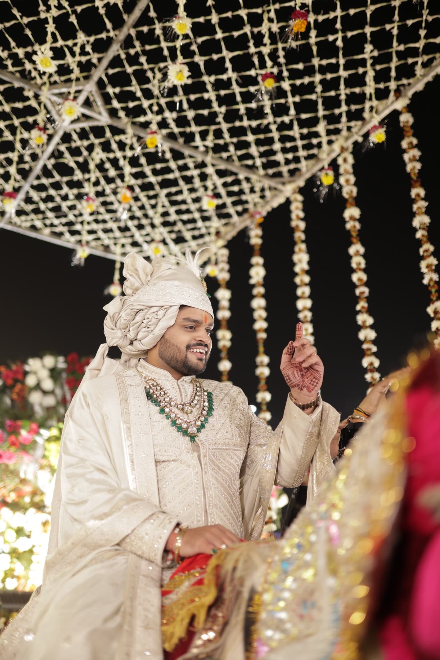 Arjun on horseback during the baraat procession, crowd celebrating below