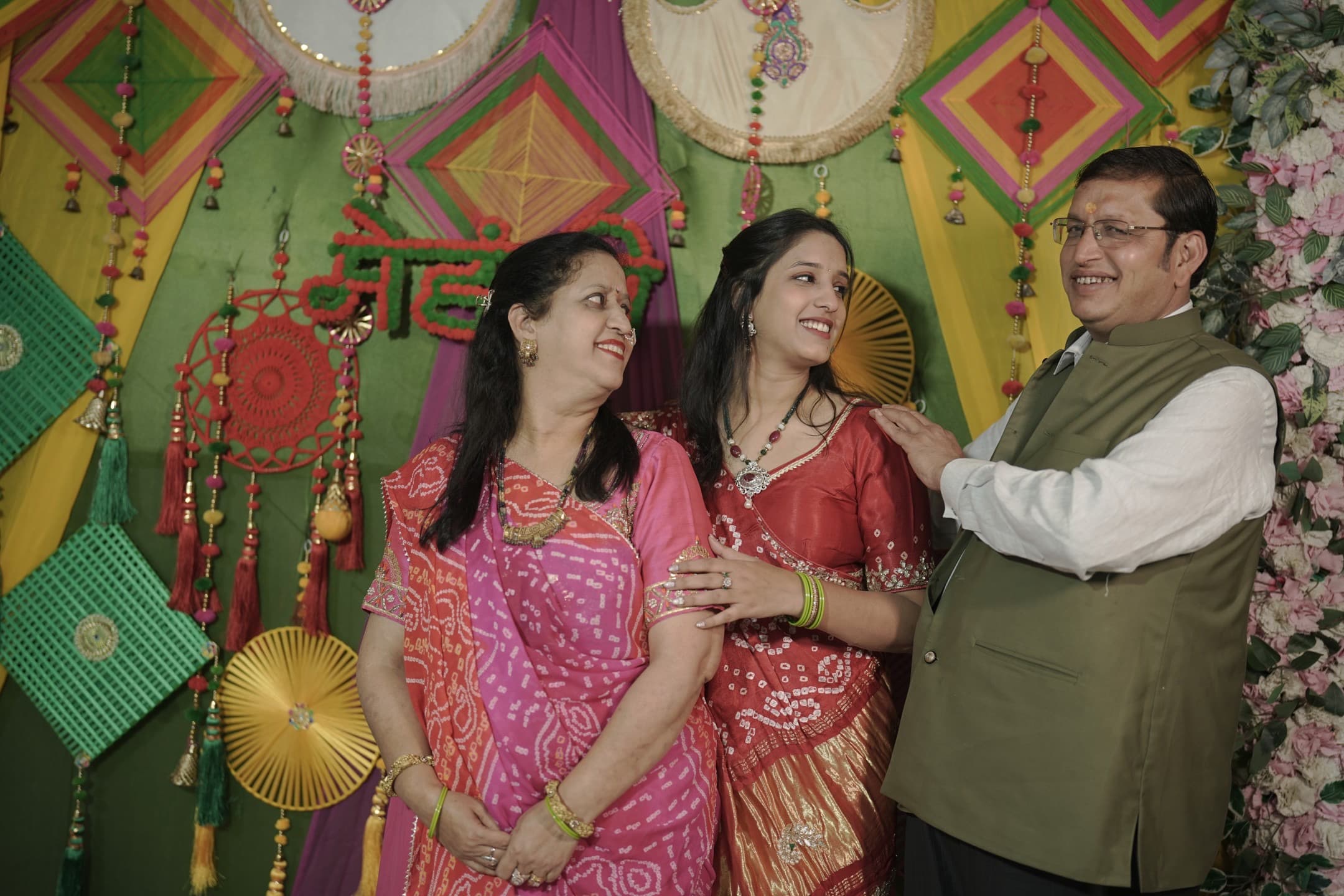 Shagun with her parents at the mehndi ceremony backdrop